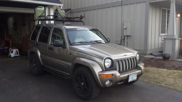 With my home built jerry can mounts, rock sliders, roof rails, and roof basket.