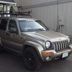 With my home built jerry can mounts, rock sliders, roof rails, and roof basket.