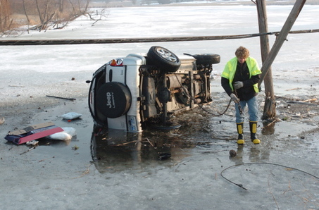 A tow-truck operator attempts to remove a Michigan KJ from a swamp after teenagers awkwardly parked it there