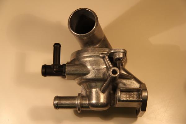 PHOTO OF THE OTHER SIDE VIEW OF THE ORIGINAL EQUIPMENT ENGINE THERMOSTAT ASSEMBLY